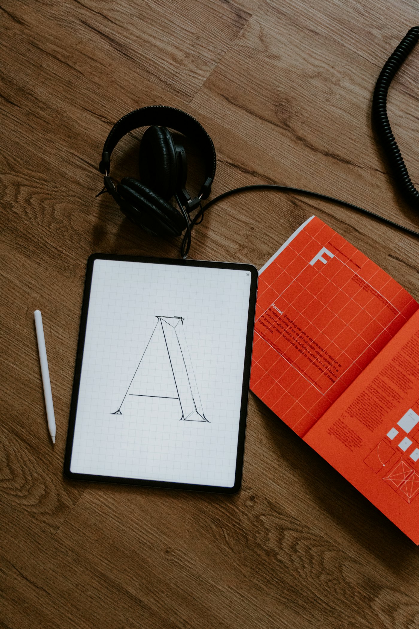 A sketchbook, pencil and a letter print on a desk
